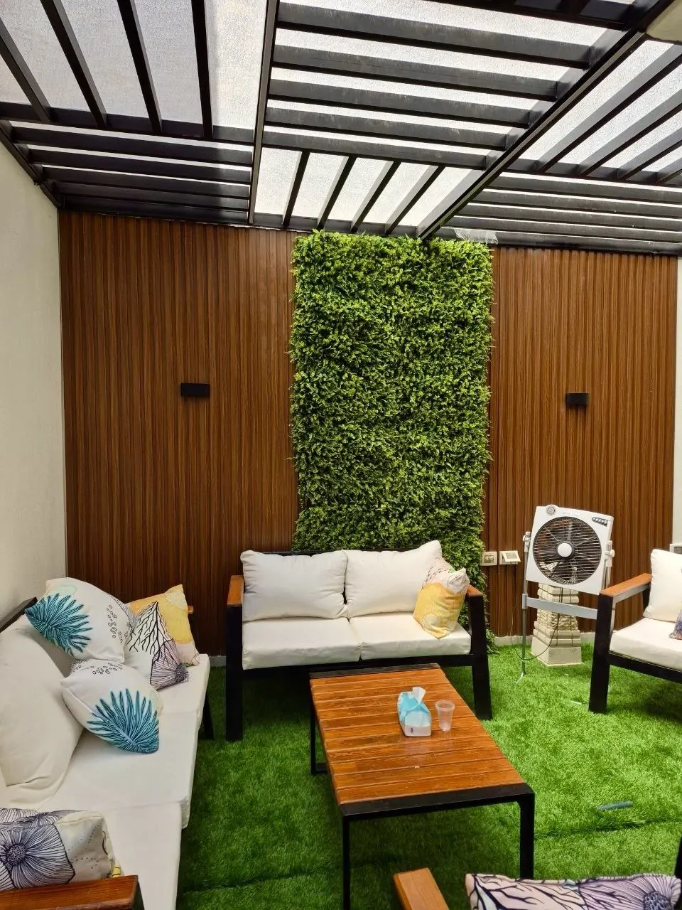 Artificial turf underfoot in a shaded courtyard lounge
