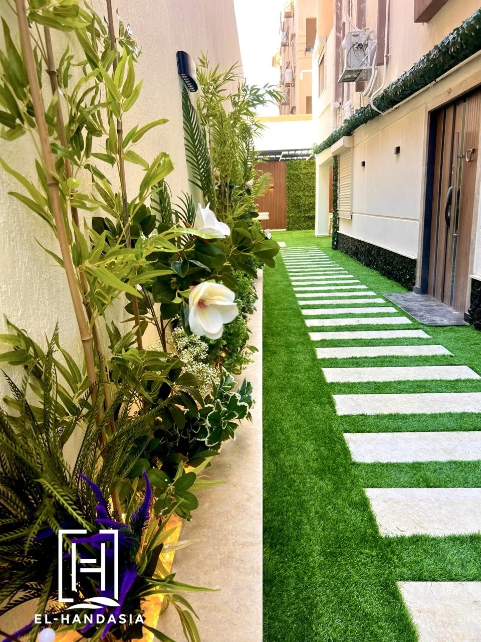 Planted side garden with stone planter beds and evergreen screening