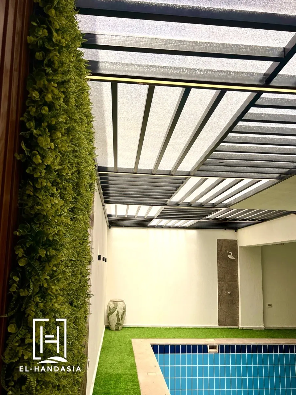 Linear lighting along a pool courtyard wall for evening use